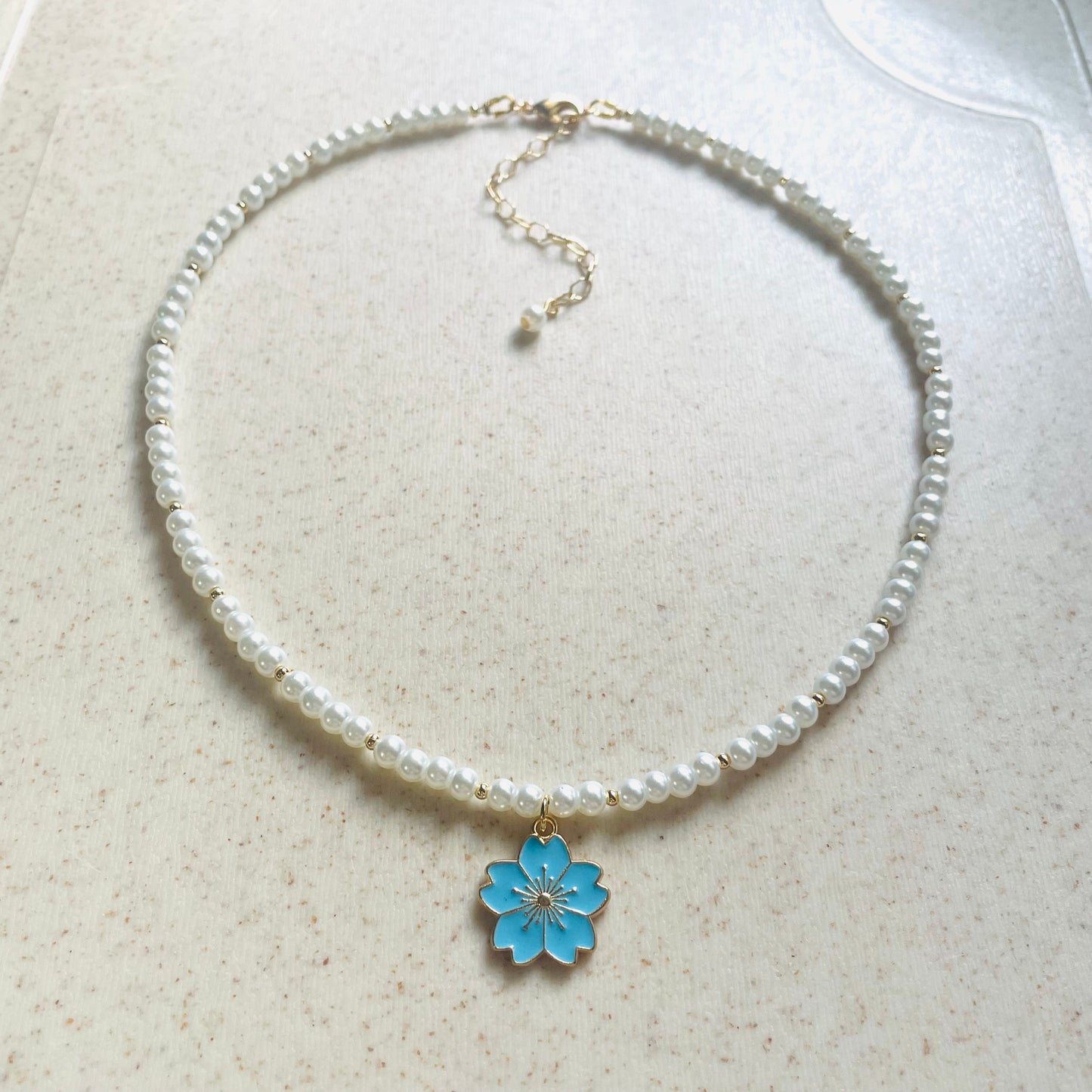 Set de collar y pulsera de perla sintética con dije flor de cerezo