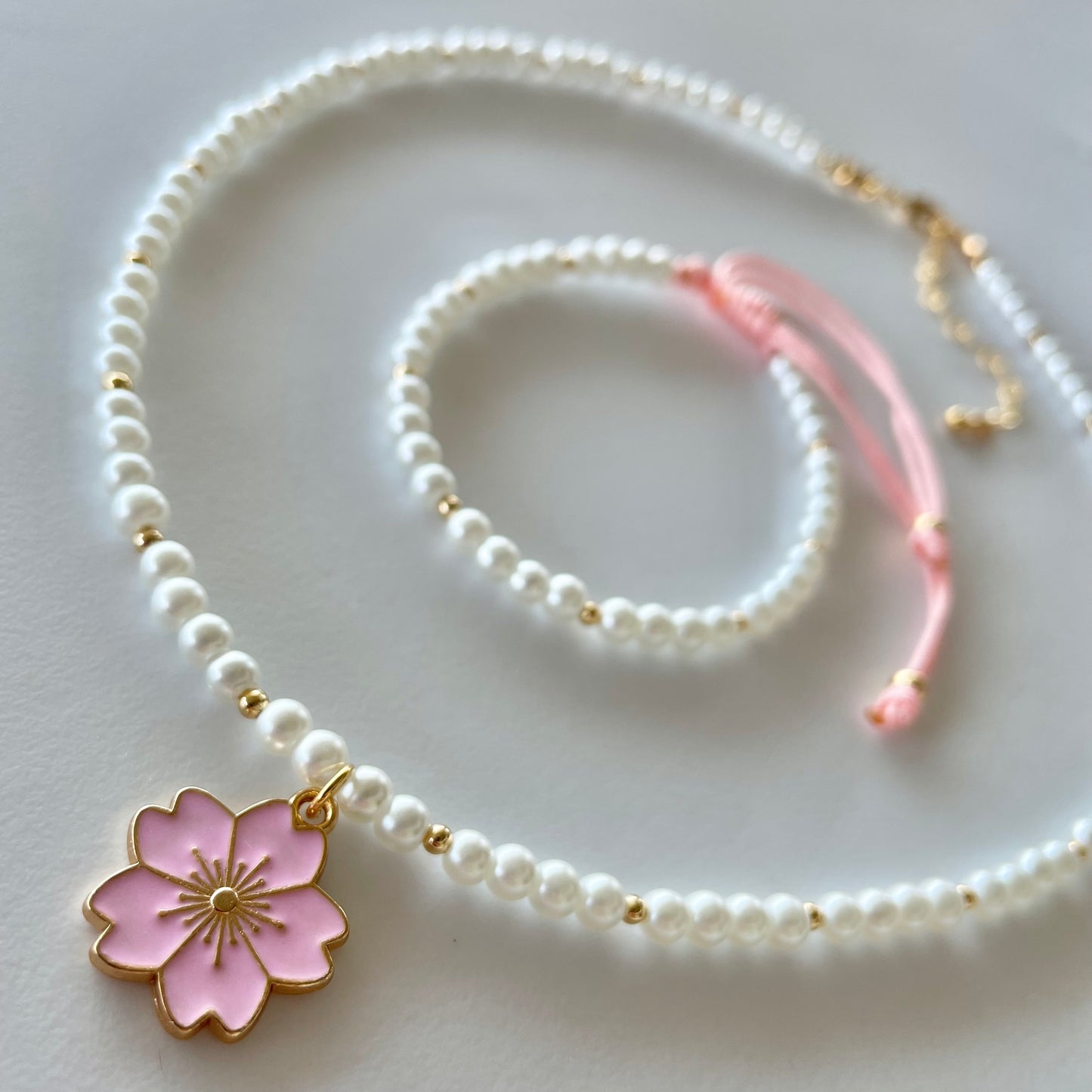 Set de collar y pulsera de perla sintética con dije flor de cerezo